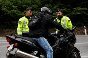 La policia revisant una motocicleta.