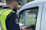 Un agent de policia fent un control d'alcoholèmia a un conductor