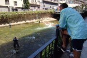 Uns turistes contemplant un parell de pescadors a la capital, ahir.