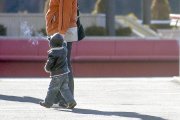 Un nen, de la mà de la seva progenitora.