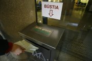 Un usuari diposita un full groc a la bústia de la CASS.