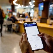 Una persona utilitzant un telèfon intel·ligent a l’edifici del Govern.