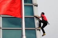 Un home escala l'edifici més alt de Taiwan sense protecció.
