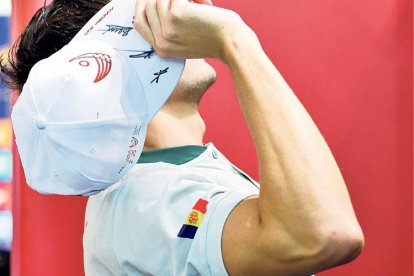 El nedador Kevin Teixeira llança una gorra commemorativa dels Jocs al públic present als Serradells.