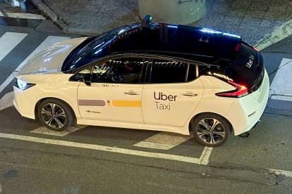 Un taxi Uber parat a la sortida d’una discoteca.