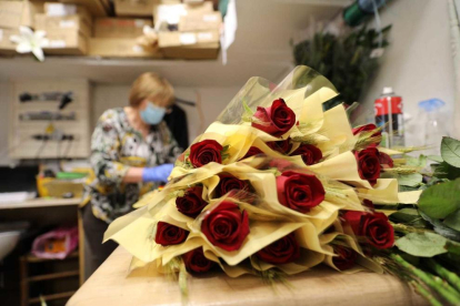 Els treballadors d'una floristeria preparen roses que els clients han encomanat