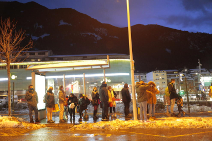 Gent esperant a una parada d'autobús