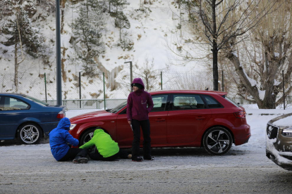 Turistes i residents equipant els seus vehicles per la neu acumulada