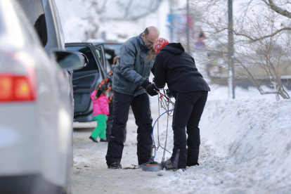 Turistes i residents equipant els seus vehicles per la neu acumulada