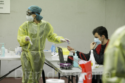 Dos membres de la Creu Roja preparen un test TMA