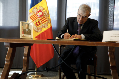 El ministre Ladislau Baró escrivint un missatge al llibre de condolences per Toni Martí