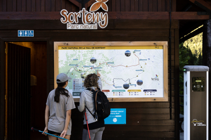 Dues excursionistes consulten el mapa de la vall de Sorteny.