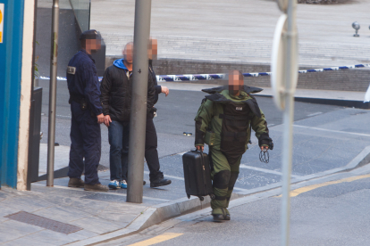 Un policia del Tedax revisant una maleta abandonada.