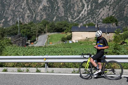 Un ciclista mira l’aplicació al mòbil.