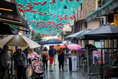 Turistes buscant restaurant sota la pluja la tarda d’ahir.