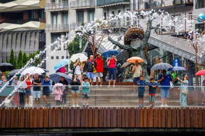 Diversos turistes a la plaça de la Rotonda observant les fonts.