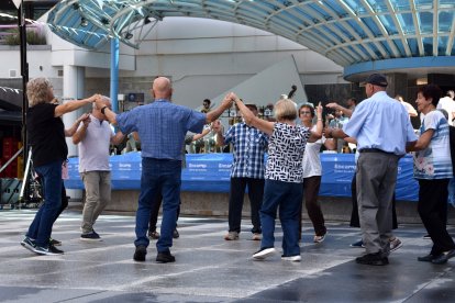 Un grup de persones ballant sardanes a la plaça dels Arínsols d'Encamp.