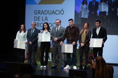 Els alumnes del bàtxelor d'administració d'empreses i els màsters en Dret i Educació pujen a l'escenari per rebre els diplomes