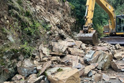 L'excavadora retirant els blocs rocosos de la carretera