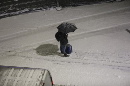 Un vianant protegint-se de la neu.