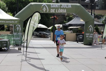 L'arribada d'un pare i un fill a la meta de la plaça de la Germandat.