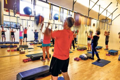 Usuaris d’un gimnàs participen d’una classe dirigida.
