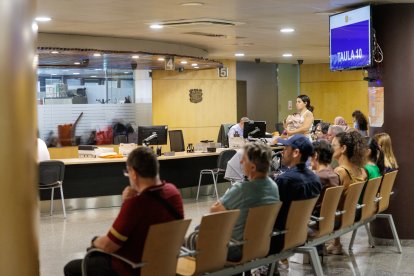 Ciutadans esperant per ser atesos a Tràmits.