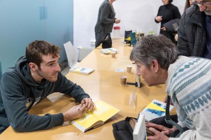 Un dels autors signant el llibre.