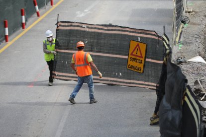 Uns treballadors obren el pas a l’accés a una obra.