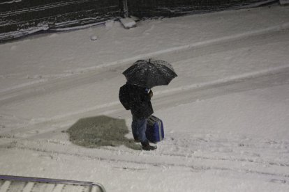 Un vianant protegint-se de la neu.