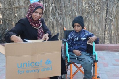 Una família de Gaza amb un paquet d'ajuda humanitària d'UNICEF.