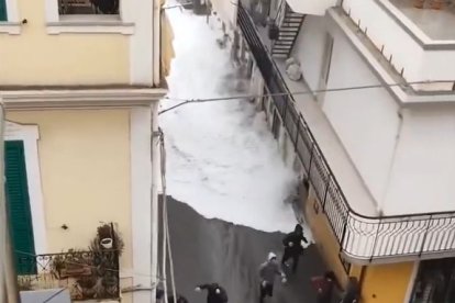 Unes persones corren per no ser engolides per l'aigua a un poble d'Itàlia.