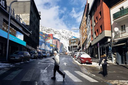 Un home caminant pels carrers del Pas den un dia de neu.