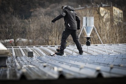 Un treballador comunal instal·lant un dispensador de pinso en una taulada.

Foto: Comú d'Andorra la Vella/Tony Lara