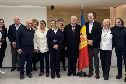 Francesc Llorens i Joan Argemí, a banda i banda de la bandera, amb treballadors i representants del Consell Superior de la Justícia.