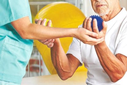 Un pacient sent atès per un fisioterapeuta.