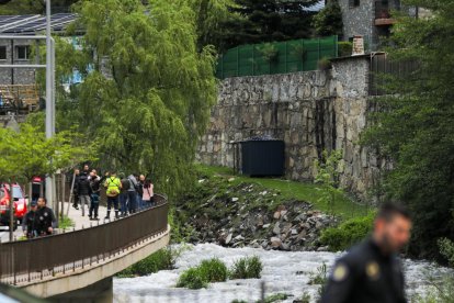 Amb el cabal del riu més baix, un policia tapant la troballa del cos, al vespre.