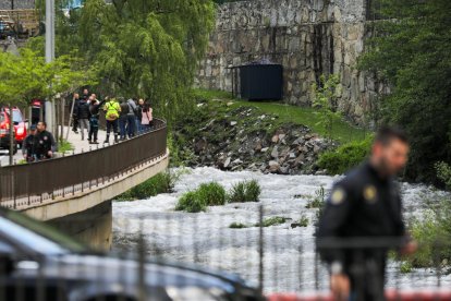 Amb el cabal del riu més baix, un policia tapant la troballa del cos, al vespre.