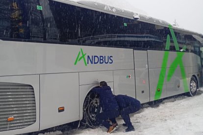 Conductors posant cadenes a un autobús aquest matí