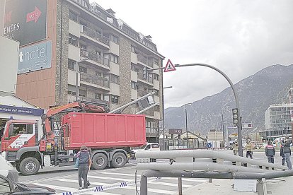 Un camió grua trenca un panell informatiu