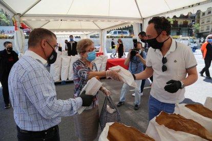 El cap de Govern i el cònsol major lauredià repartint pans en la diada de Canòlich