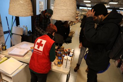una treballadora de la Creu Roja a la botiga solidària