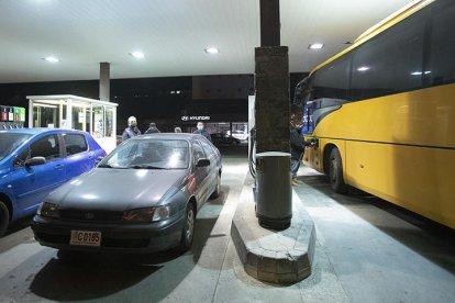 El conductor d'un bus omplint el dipòsit, ahir.