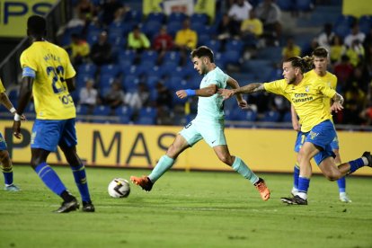 El lateral de l'FC Andorra Martí Vilà perseguit per Álvaro Jiménez, de Las Palmas, al partit d'ahir.