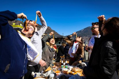 Un grup de persones menjant calçots ahir a la plaça del Poble de la capital.