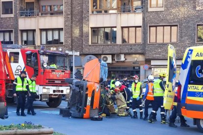 Efectius dels bombers traient la dona de dins del vehicle bolcat.