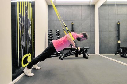 FLEXIONS AMB TRX: regulem el TRX a posició baixa (al costat del genoll). D'esquenes, passem el TRX per sobre de les espatlles i l'agafem per dins de les nanses. Braços més amples que les espatlles i fem una flexió mantenint l'esquena ben recta.
