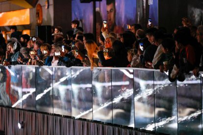 Un grup de persones mirant l'espectacle de les fonts de llum i aigua del passeig del riu d'Andorra la Vella.