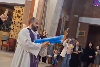Un cura beneeix amb una pistola d'aigua