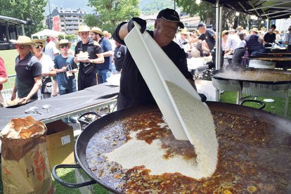 Un cuiner ahir tirant arròs a la paella.